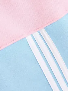 Detailaufnahme von rosa und hellblauem Fleece-Hundehoodie mit weißen Streifenakzenten.