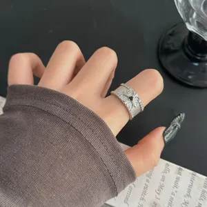 Bague large rétro en argent avec texture de grille, pierre centrale noire et cristaux étincelants.