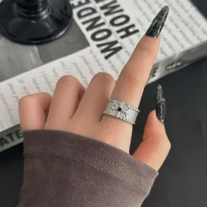 Bague argentée large vintage avec motif de croix en pierre noire, style gothique rétro.