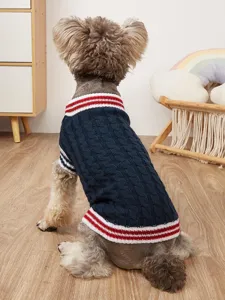 Detailed shot of a navy blue cable-knit dog sweater with red and white striped cuffs.