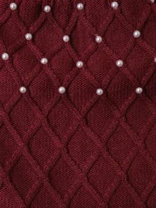 Close up of burgundy knit pet sweater detail with diamond pattern and faux pearls.