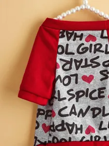 Close-up detail of pet dog t-shirt with red sleeves and printed letters and hearts pattern.