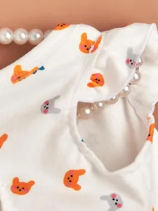 Close-up detail of cute pet vest with lovely animal print and delicate pearl decoration.
