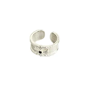 Bague ouverte argentée rétro sculptée avec texture de grille et pierre centrale.