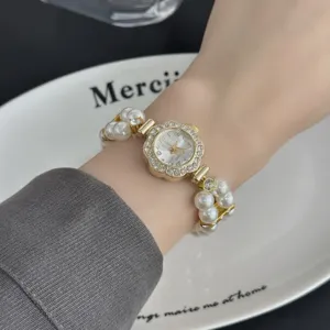 Primer plano detallado de reloj de cuarzo para mujer con pulsera de perlas y esfera.