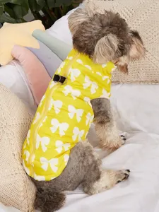 Vue détaillée du gilet d'hiver pour chien en tissu jaune avec motif de nœuds blancs.
