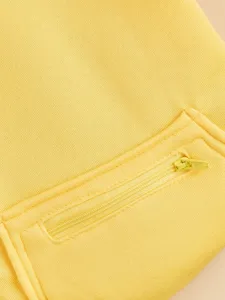 Solid yellow pet hoodie detail view with zipper pocket, soft cotton fabric for dogs and cats.