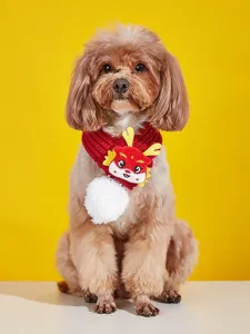 Detail view of red knitted pet scarf with 3D dragon horns and white pom-pom for cats and dogs.