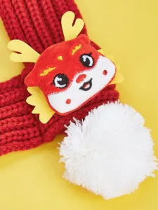 Detailed close-up of red knit pet scarf featuring 3D dragon horns and white pom pom.