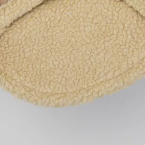 Detailed close-up of warm beige sherpa fleece and brown suede pet clothing fabric texture.