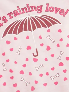 Close-up detail of cute dog t-shirt fabric featuring umbrella and heart print.
