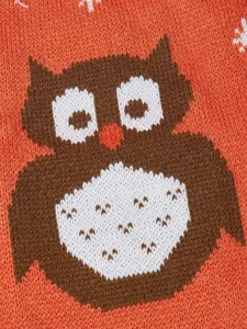 Detailed close-up view of a cute knitted owl pattern on vibrant orange winter sweater fabric.