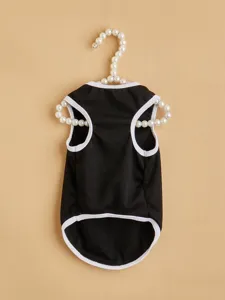 Close-up detail of black dog vest with white trim displayed on a delicate pearl hanger.