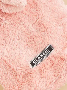 Gros plan détail du tissu de vêtement pour animaux en peluche rose avec étiquette chic.