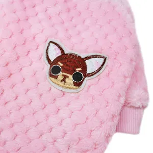 Pink fleece pet clothing detail showing cute embroidered dog patch and warm flannel fabric texture.
