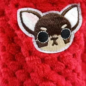 Close-up of red fleece pet clothing with cute puppy embroidery detail, soft and warm fabric.