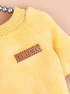 Cozy yellow fleece pet sweatshirt with classic leather label, warm winter pet apparel.