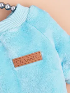 Close-up detail of soft blue fleece pet winter clothing with a classic leather patch.