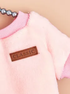 Pink pet plush winter sweater detail view, soft flannel fabric with classic leather label.