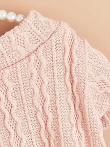 Close-up detail of pink knitted pet sweater, featuring cozy cable knit ribbed texture and collar.