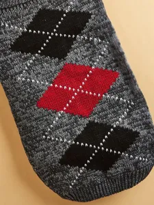 Close-up view of knitted pet sweater fabric showcasing a classic argyle diamond pattern.