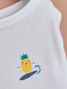 Cute cartoon pineapple print detail on white pet vest, soft fabric close-up shot.