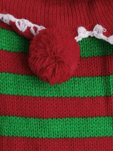 Close-up of Christmas pet sweater knit red green stripes white collar pompom detail.