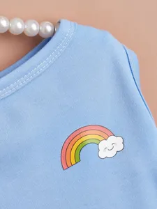 Cute pet dress detail with rainbow cloud print, blue fabric, soft and comfortable for dogs.