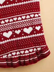 Close-up detail view of red and white knit pet sweater featuring lovely heart patterns and ruffle hem.