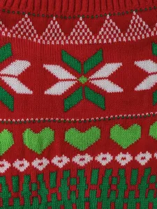 Detailed knit fabric of pet dog sweater with red and green Christmas heart and snowflake patterns.