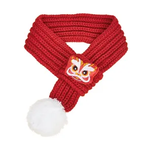 Red knitted pet scarf with white pom-pom and festive lion patch, warm detail for dogs and cats.