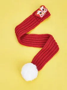 Red knit pet scarf detail featuring festive lion dance patch and fluffy white pom-pom.