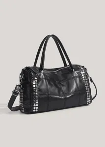 Détail élégant du sac porté épaule matelassé noir avec clous métalliques et poignées.