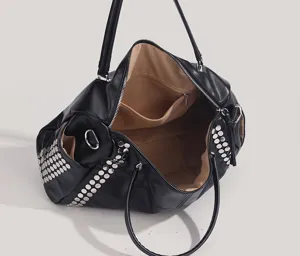 Gros plan détaillé du sac à main noir en cuir avec clous métalliques et grand intérieur.