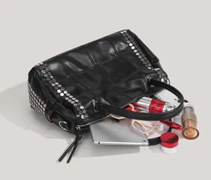Vue détaillée du sac à main matelassé noir clouté montrant son grand espace de rangement.