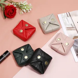 Mini leather pouch detail shot showing exquisite button closure and fine grain texture.