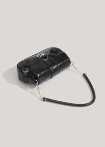 Detail shot of black glossy motorcycle baguette shoulder bag with metallic buckle and chain strap.