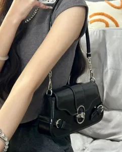 Chic black patent leather baguette underarm bag with silver chain, stylish and versatile.