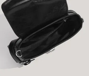Detailed view of black shoulder bag interior, featuring smooth zipper pocket and metal ring.