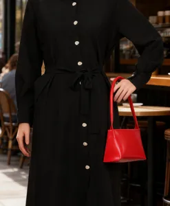 Red structured baguette shoulder bag detail view, minimalist style fashion accessory, chic.
