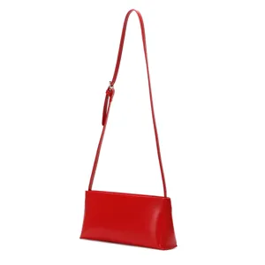Red minimalist baguette shoulder bag detail view, sleek long strap fashion handbag.