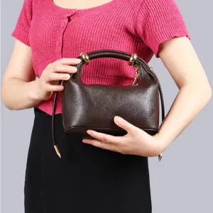 Brown leather dumpling handbag for women, chic minimalist shoulder bag with metal ring handle.