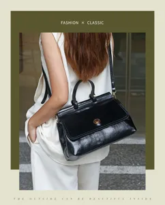 Classic black patent leather handbag for women, spacious top handle commuter shoulder bag.