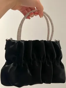Black pleated cloud handbag with sparkling rhinestone top handles, elegant evening shoulder bag.