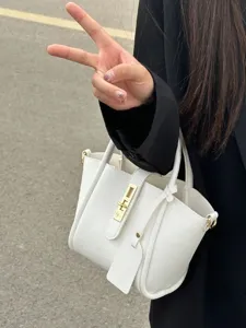 White pebbled leather bucket handbag with gold lock hardware, versatile crossbody bag.