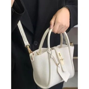 White lychee pattern leather bucket bag detail showing soft texture and refined gold hardware.