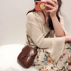 Detailansicht der vintage braunen Ledertasche, kombiniert in einem lässigen Alltags-Outfit.