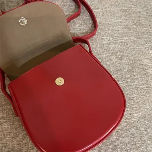Rote Umhängetasche Detail, elegante Ledertasche mit sicherem Magnetverschluss für Damen.