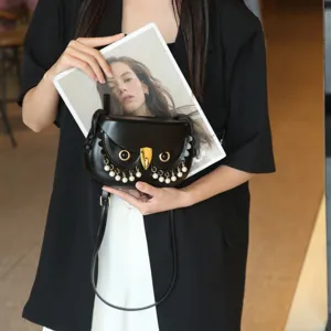 Nahaufnahme der einzigartigen Eulen-Satteltasche mit Perlenfransen und goldenen Beschlägen.