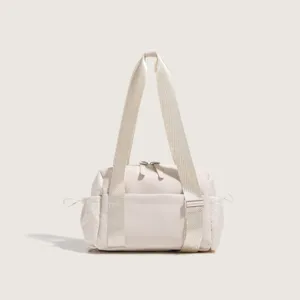 Detailed view of beige nylon sports fitness bag with dual handles and side pockets for travel.